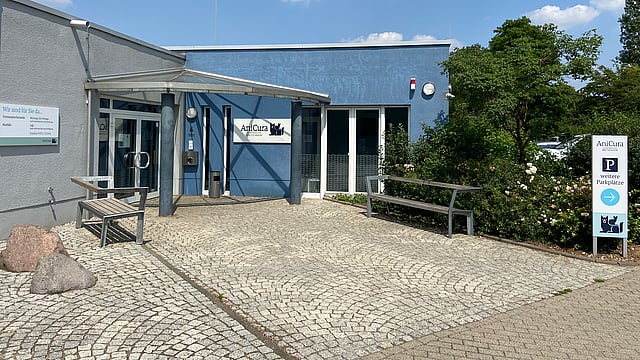 Ein Gebäude mit einer blauen Wand und einer Bank.