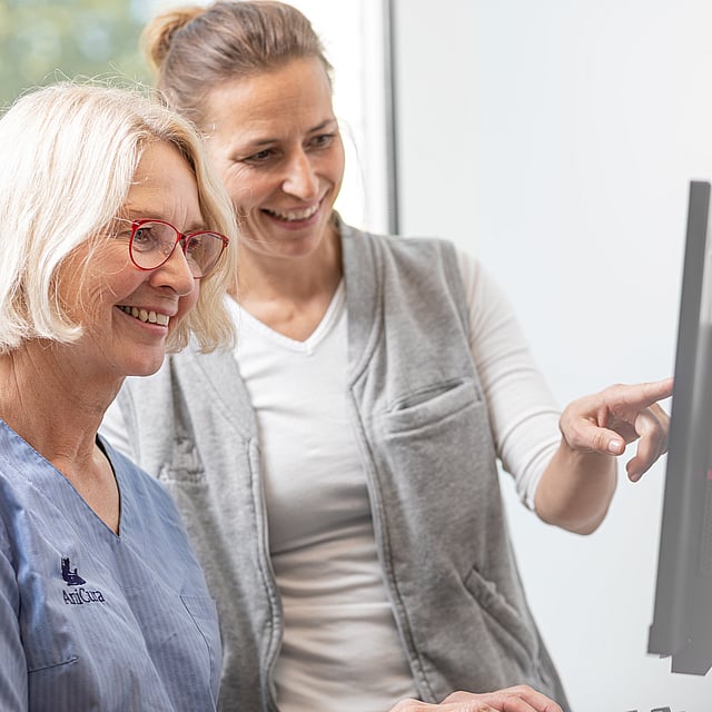 Eine Person, die auf einen Computerbildschirm zeigt.