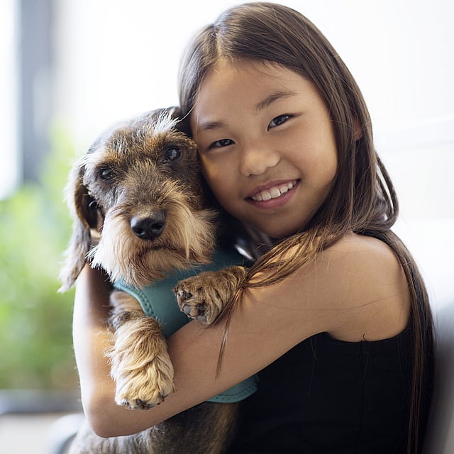 Ein Kind, das einen Hund umarmt.
