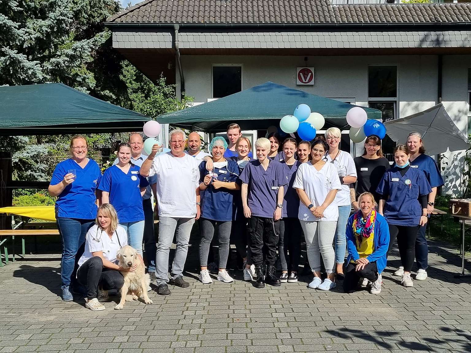 Ein Gruppenbild des Anicura Teams. Ein paar der Mitarbeiter haben Luftballons.