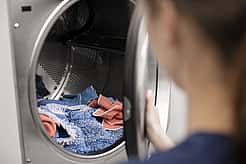 Die Waschmaschine wird mit Handtüchern befüllt.