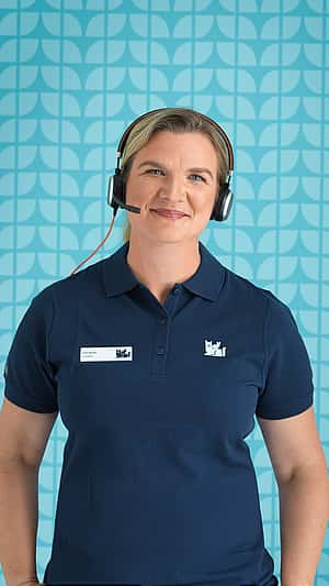 Eine Frau mit Headset lächelt in die Kamera.