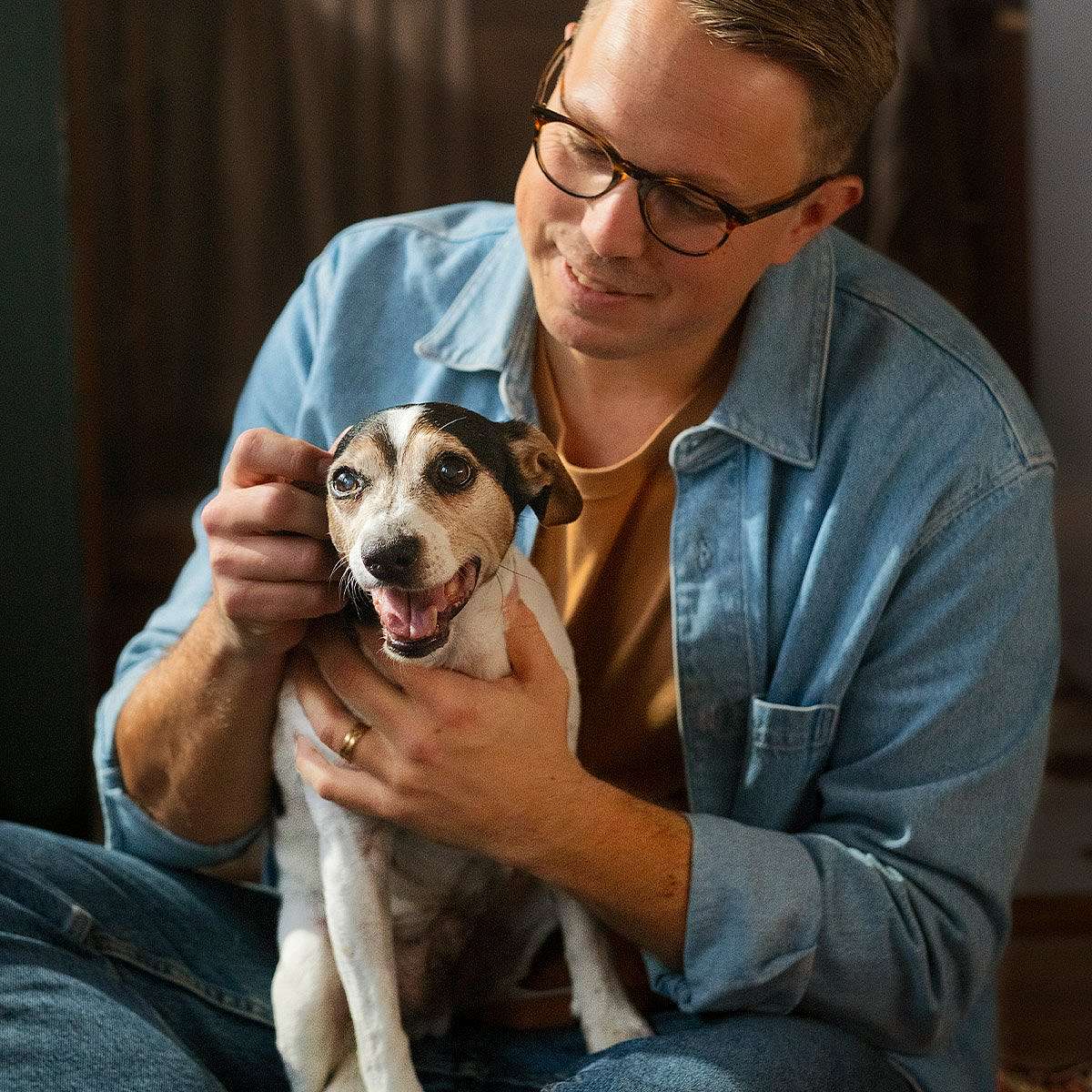 Man cuddling with dog.