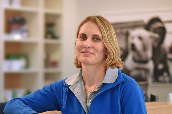 Eine Person, die sich an ein Holzgeländer lehnt.