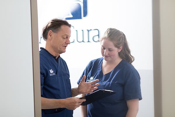 Eine Person und eine Person in Kitteln, die sich unterhalten.