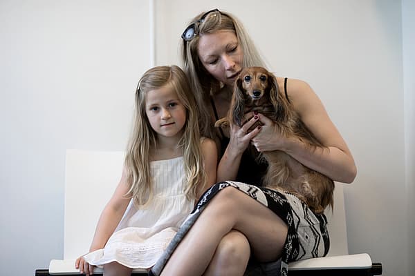 Eine Person und ein Kind, die einen Hund halten.