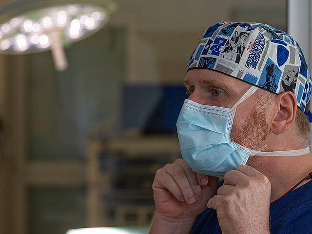 Eine Person, die eine chirurgische Maske trägt.