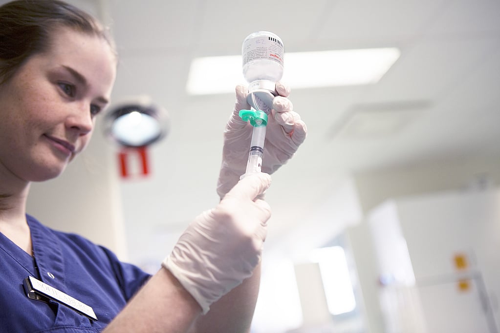 Eine Krankenschwester hält einen Infusionstropf in der Hand.