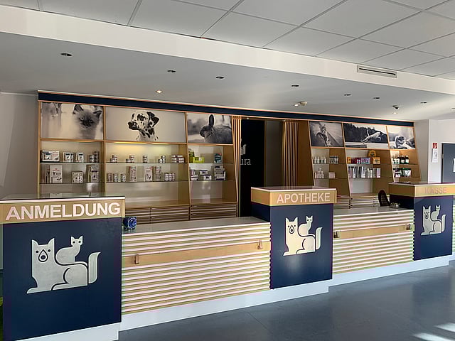 Die Rezeption von Anicura ist sehr edel mit hellbraunen Elementen gestaltet. Es gibt drei Schalter, auf denen Anmeldung, Apotheke und Kasse steht.