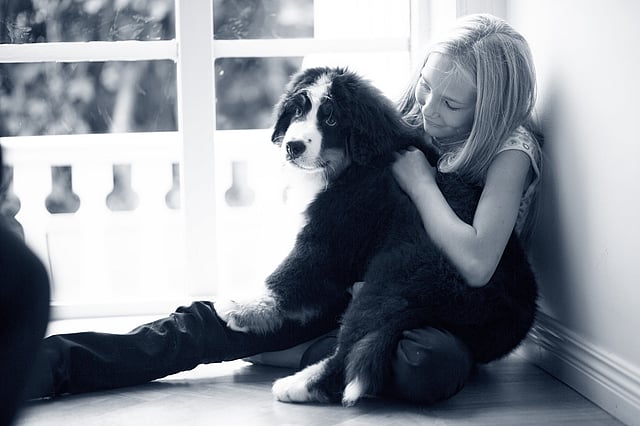 Ein Kind, das mit einem Hund auf dem Boden sitzt.