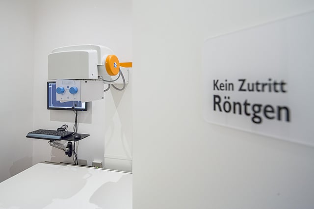 Eine weiße Wand mit einem Computer und einem Monitor.